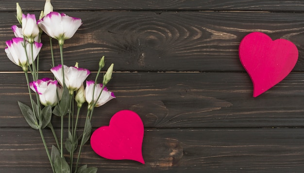 Kostenloses Foto blüht blumenstrauß mit herzen auf holztisch