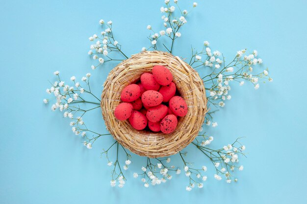 Blumen neben Korb mit Eiern für Ostern