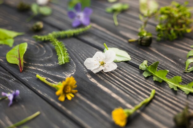 Blumen und Blätter auf Holztisch