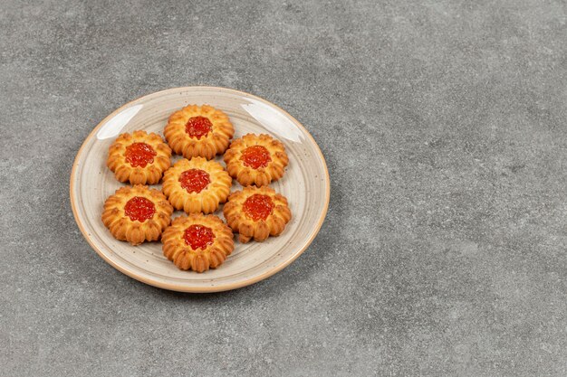 Blumenförmige Kekse mit Gelee auf Keramikplatte
