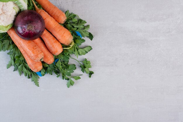 Blumenkohl, Karotten und Zwiebeln auf blauem Teller. Hochwertiges Foto