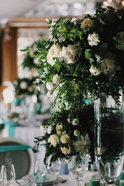 Blumenstrauß aus weißen Rosen steht in der Mitte des Tisches im Restaurant