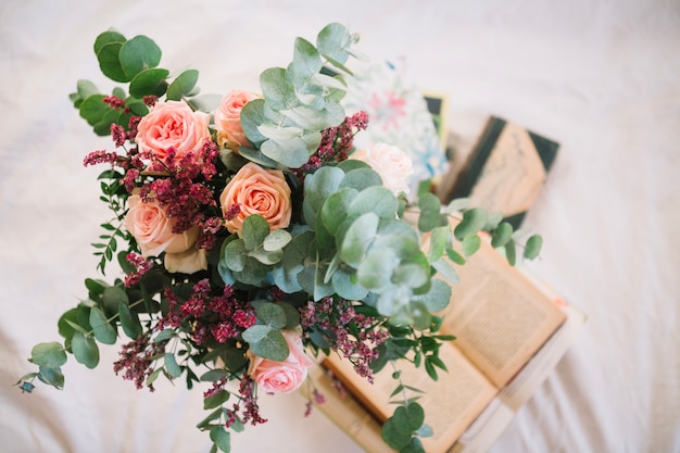 Kostenloses Foto blumenstrauß, der auf büchern steht