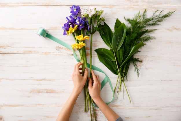 Blumenstrauß der Draufsicht von Blumen auf Holztisch