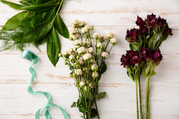 Blumenstrauß der Draufsicht von Blumen auf Holztisch