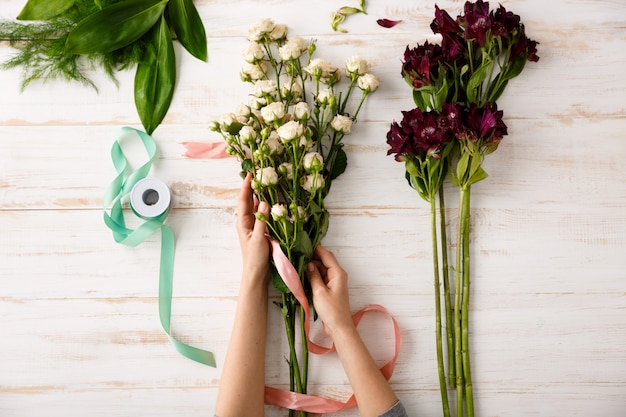 Blumenstrauß der Draufsicht von Blumen auf Holztisch