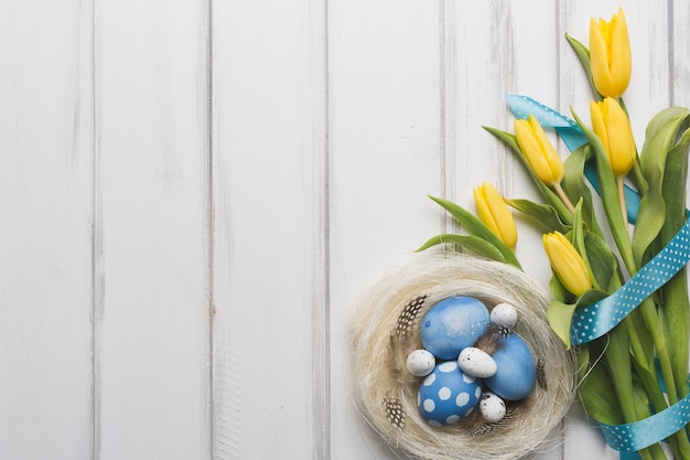 Blumenstrauß in der Nähe von Nest mit Eiern