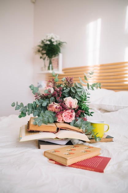 Blumenstrauß und Bücher auf dem Bett