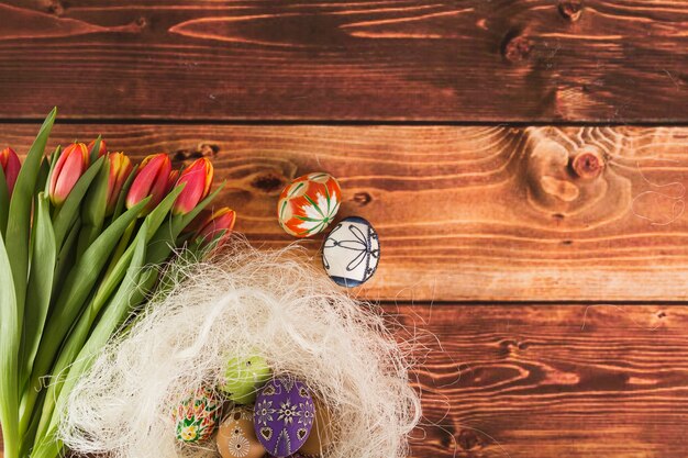 Blumenstrauß von Tulpen nahe Nest und Eiern