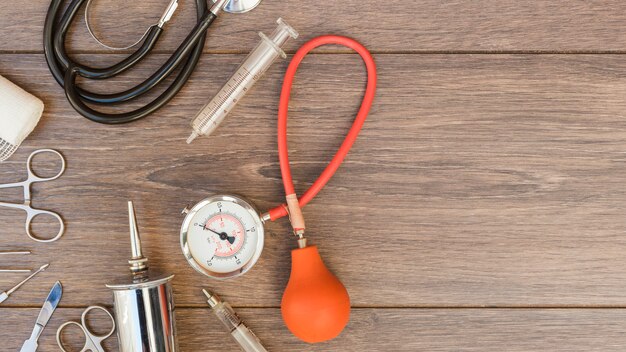 Blutdruckmessgerät; Stethoskop und medizinische Geräte auf Schreibtisch aus Holz