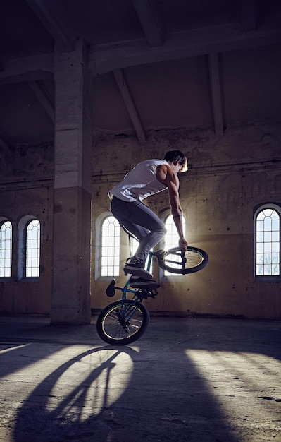 Kostenloses Foto bmx-stunt- und sprungreiten in einem indoor-park im sonnenlicht.