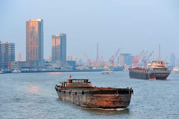 Boot im Fluss Huangpu mit urbaner Architektur von Shanghai