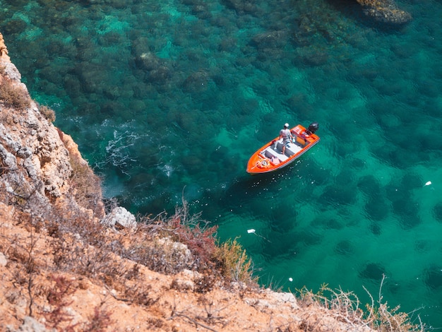 Boot schwimmt auf dem Wasser neben einer Klippe