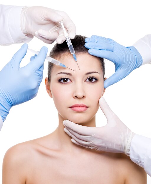 Botox-Injektion in die Augenbraue auf weiblichem Gesicht lokalisiert auf Weiß