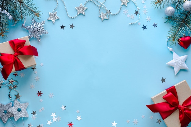 Boxen mit Geschenken und Weihnachtsdekorationen auf blauer Oberfläche