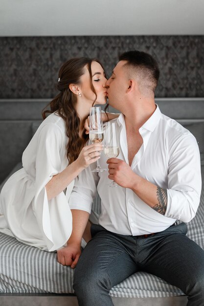 Bräute Paar Küssen Halten Gläser Mit Getränk Sitzen In Der Wohnung
