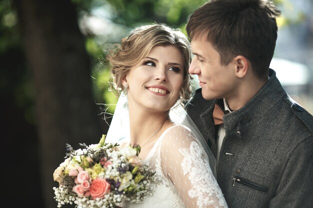 Bräutigam hinter seiner Freundin mit dem Kleid umarmen