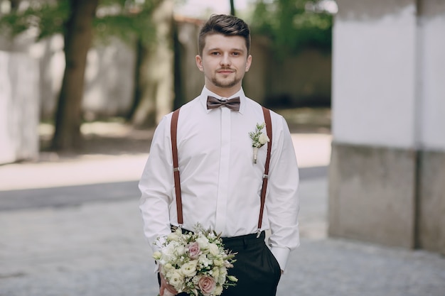 Kostenloses Foto bräutigam in strapsen mit einem blumenstrauß