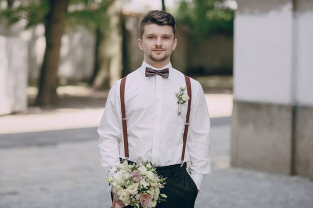Bräutigam in Strapsen mit einem Blumenstrauß