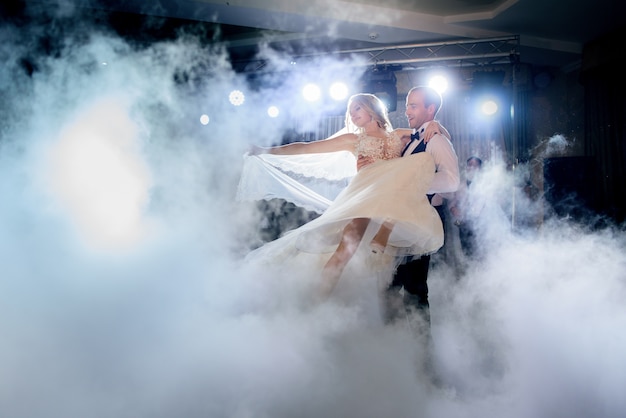 Bräutigam wirbelt Braut im Rauch tanzen zum ersten Mal