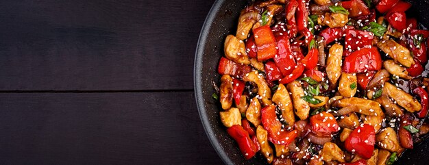 Braten Sie Hühnchen, Paprika und Frühlingszwiebeln an. Draufsicht. asiatische Küche