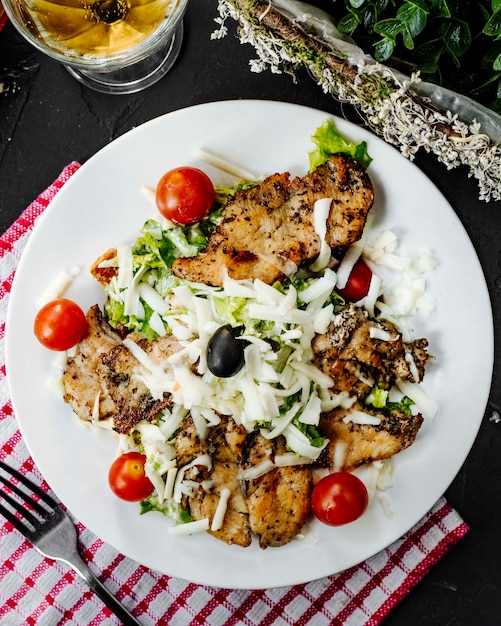 Brathähnchen mit tomatensalat und geriebenem käse