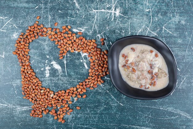 Braune Bohnen und Pilzsuppe auf blauem Hintergrund. Hochwertiges Foto