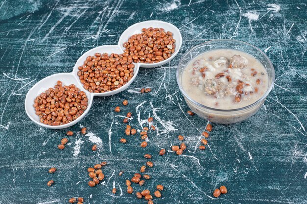 Braune Bohnen und Pilzsuppe auf blauem Hintergrund. Hochwertiges Foto