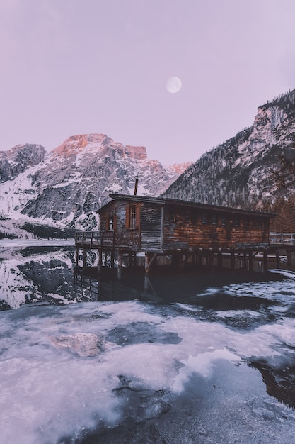 Braunes Holzhaus nahe schneebedecktem Berg