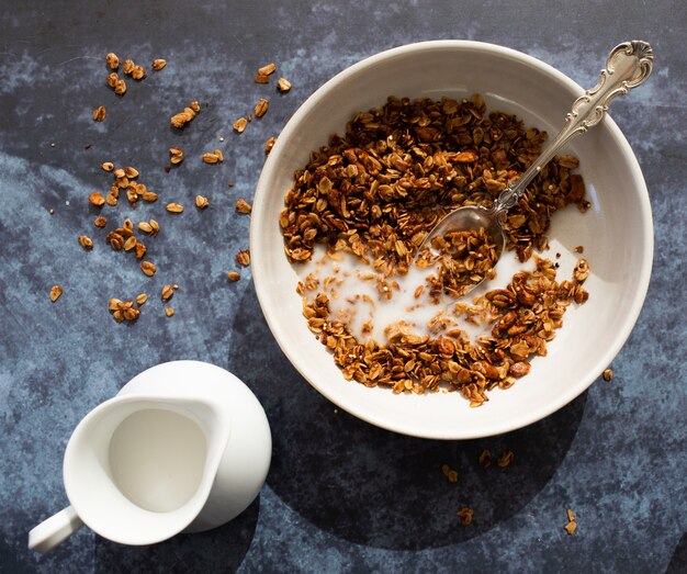 Braunes Müsli neben Krug Milch