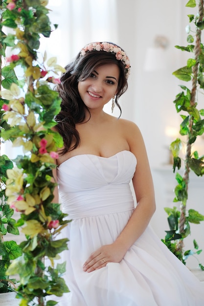 Braut auf einer Schaukel mit Blumen