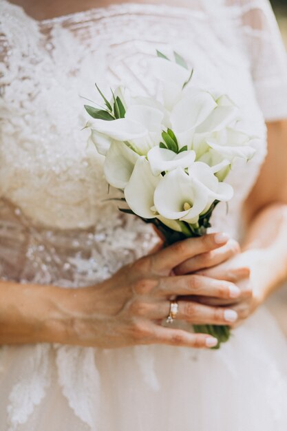 Braut, die ihren Blumenstrauß an ihrem Hochzeitstag hält