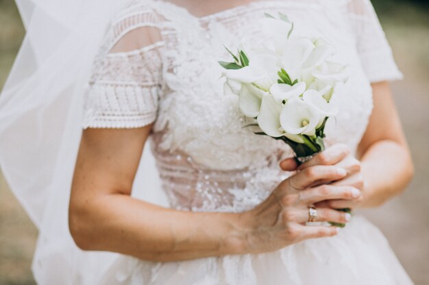 Braut, die ihren Blumenstrauß an ihrem Hochzeitstag hält