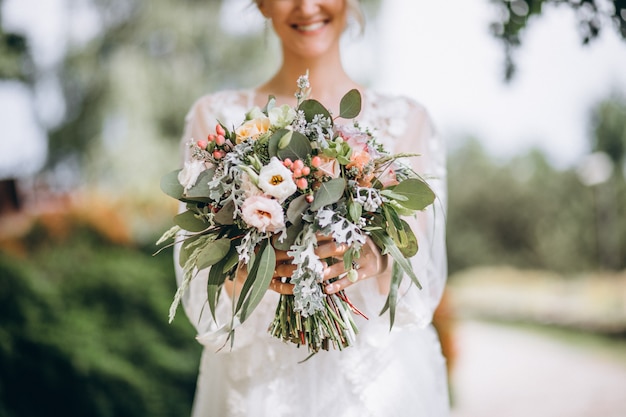 Kostenloses Foto braut, die ihren blumenstrauß an ihrem hochzeitstag hält