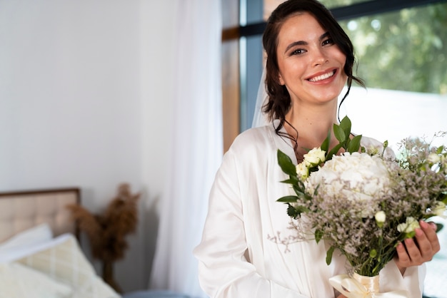 Kostenloses Foto braut, die mit mittlerer aufnahme der blumen aufwirft