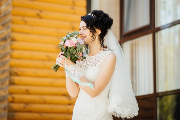 Braut mit einem Blumenstrauß, lächelnd. Hochzeitsporträt der schönen Braut. Hochzeit. Hochzeitstag.