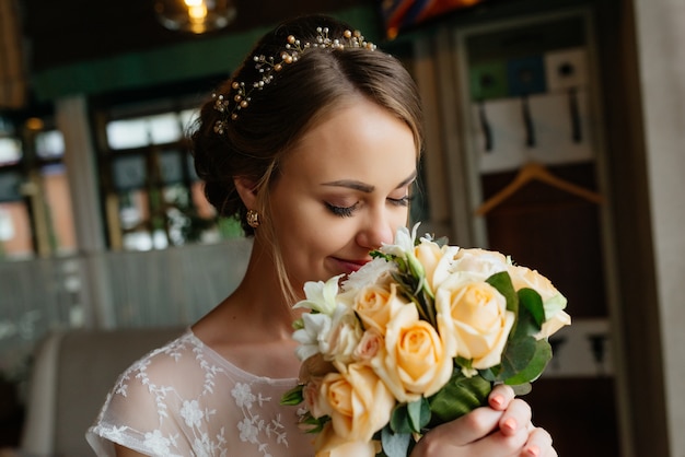 Braut mit einem Blumenstrauß, lächelnd. Hochzeitsporträt der schönen Braut. Hochzeit. Hochzeitstag.