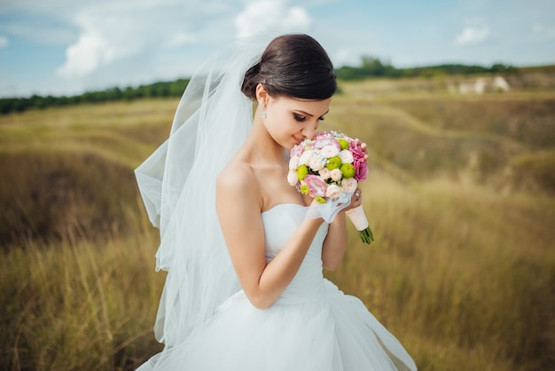 Braut mit einem blumenstrauß, lächelnd. hochzeitsporträt der schönen braut.