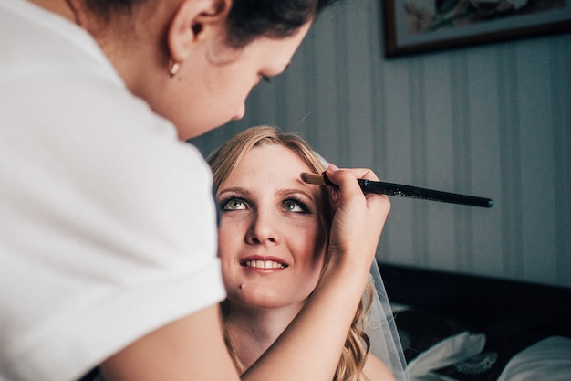 Portratvorbereitung Der Braut Am Morgen Vor Der Hochzeit Kunstler Macht Make Up Und Sie Halt Die Augen Geschlossen Kostenlose Foto