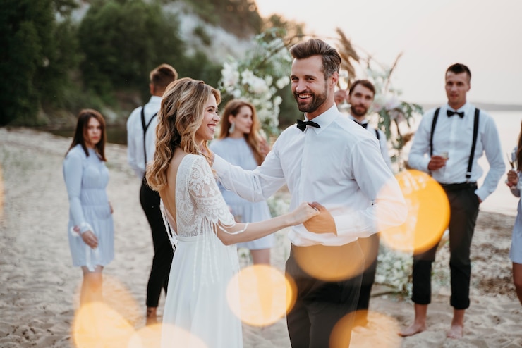 Kostenlose Foto braut und bräutigam haben ihre hochzeit mit gästen am strand