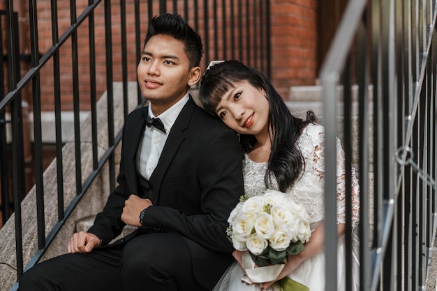 Braut und Bräutigam posieren zusammen auf Stufen