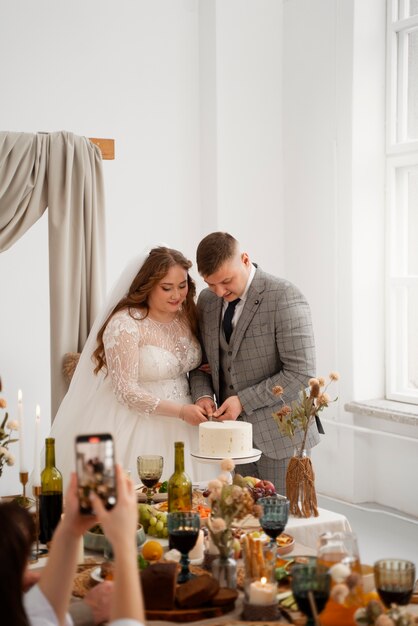 Braut und Bräutigam schneiden die Torte bei ihrer Hochzeit an