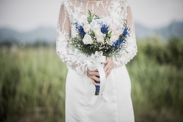 Brauthand, die Blume am Hochzeitstag hält