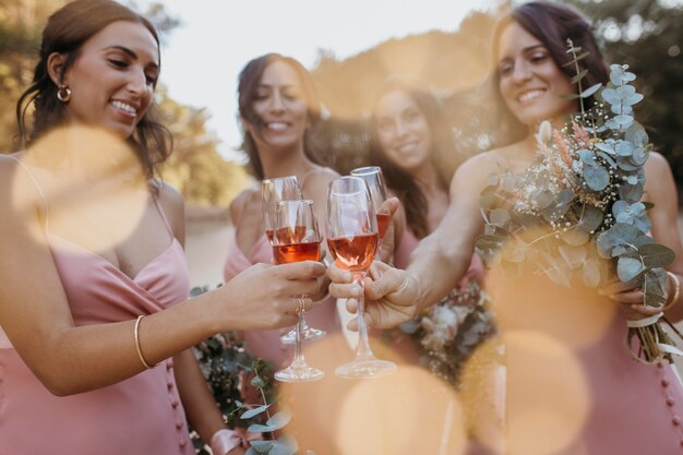 Brautjungfern in hübschen Kleidern feiern die Hochzeit im Freien