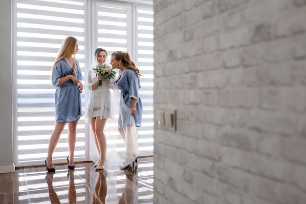 Brautjungfern mit Braut in seidiger Nachtwäsche riechen nach Hochzeitsstraußduft
