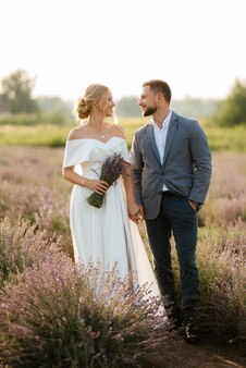 Brautpaar bei einem spaziergang im lavendelfeld