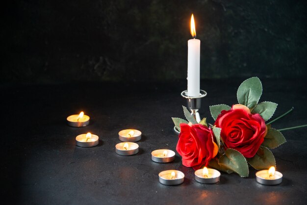 Brennende Kerzen der Vorderansicht als Erinnerung für gefallene dunkle Oberfläche