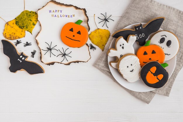 Brennendes Papier nahe Lebkuchen auf Platte und Blättern