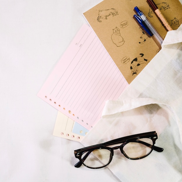 Brille in der Nähe von Notebook-Seiten