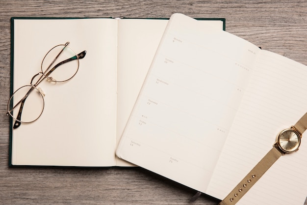 Kostenloses Foto brille und uhr auf offenen büchern